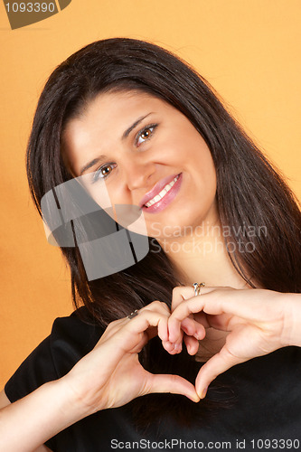 Image of Young woman making heart with hands