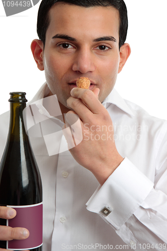 Image of Man or wine steward sniffing wine cork