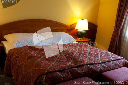 Image of dressed with a red coverlet bed