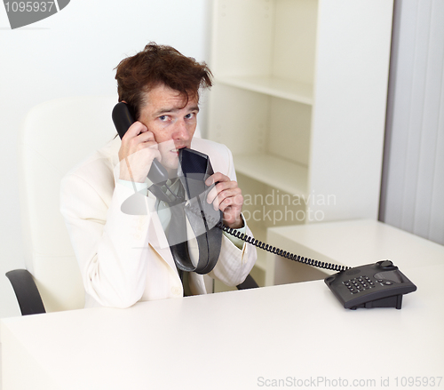 Image of Disheveled businessman talking on phone very excited