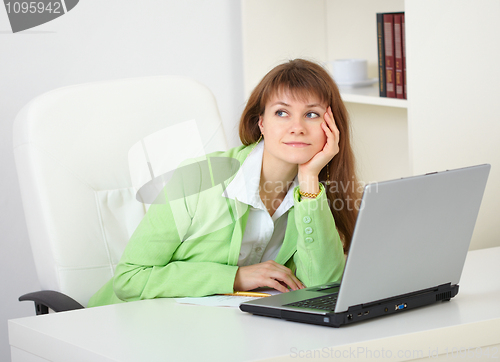 Image of Girl dreams working with laptop at office