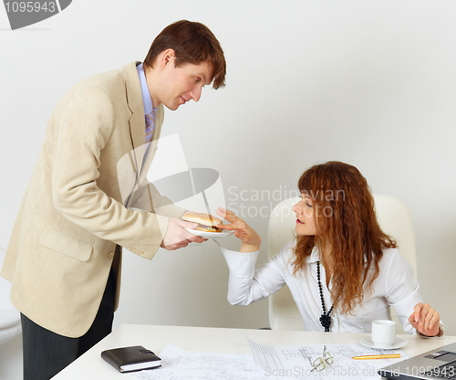 Image of Man treats woman colleague hamburger