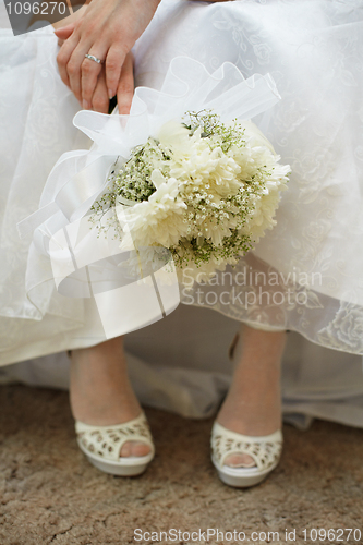 Image of Bouquet of bride against dress and shoes