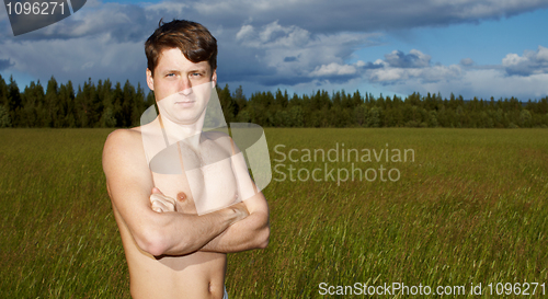 Image of Naked young man on background of field