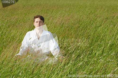 Image of Man sits in grass