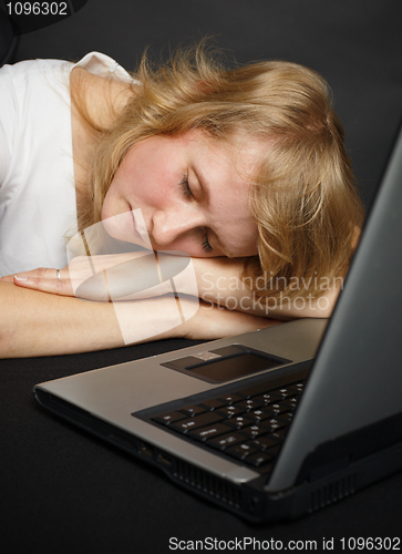 Image of Woman asleep at table near computer