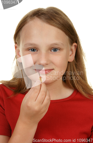 Image of young girl taking a pill