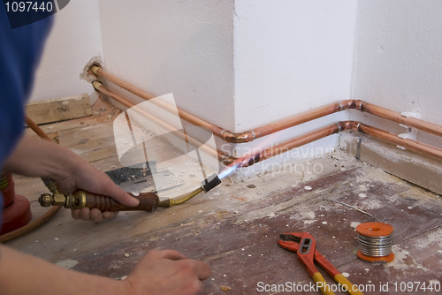 Image of plumber soldering