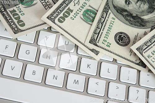 Image of Hundred dollar bills on computer keyboard