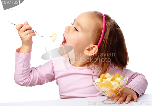 Image of Little girl eats fruit salad