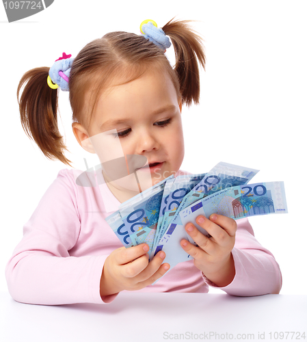 Image of Little girl with few paper euro banknotes