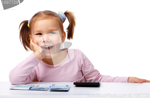 Image of Little girl with few paper euro banknotes