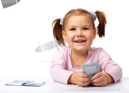 Image of Little girl with few paper euro banknotes