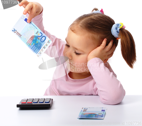 Image of Little girl with few paper euro banknotes