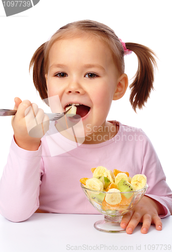 Image of Little girl eats fruit salad