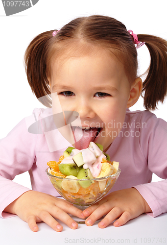 Image of Little girl licks fruit salad