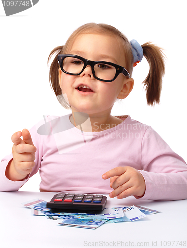 Image of Little girl plays with money