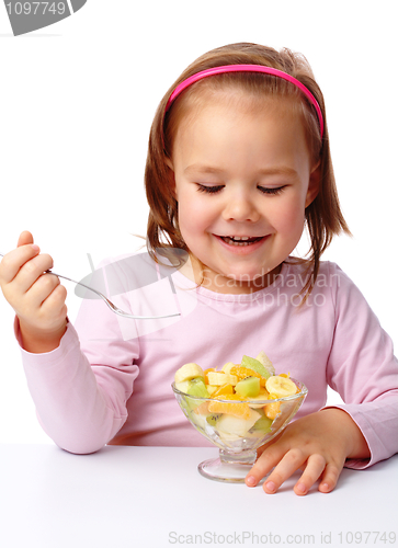 Image of Little girl eats fruit salad