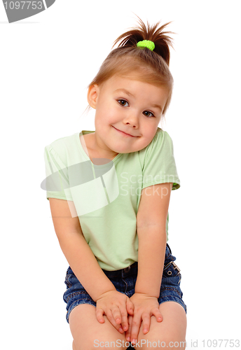 Image of Cute little girl is sitting on floor and smile