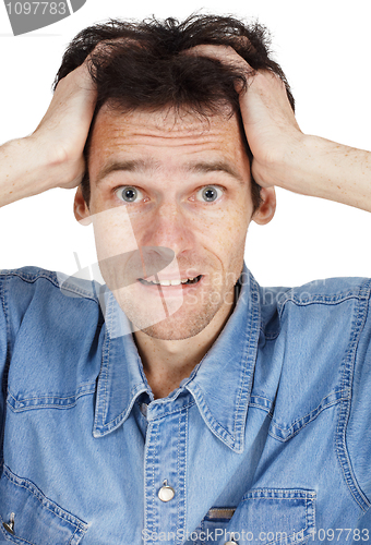 Image of Confused young man has clasped hands a head