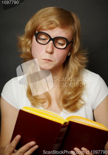 Image of Woman in funny old-fashioned glasses reading book