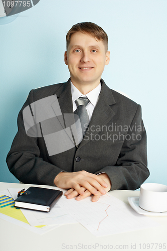 Image of Businessman sitting in an office at table