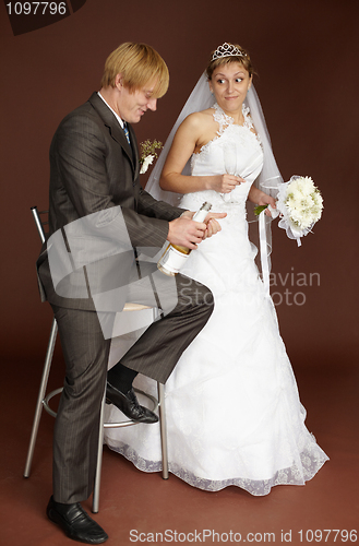 Image of Bridegroom opens champagne wine