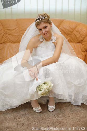 Image of Bride sitting on sofa waiting for ceremony