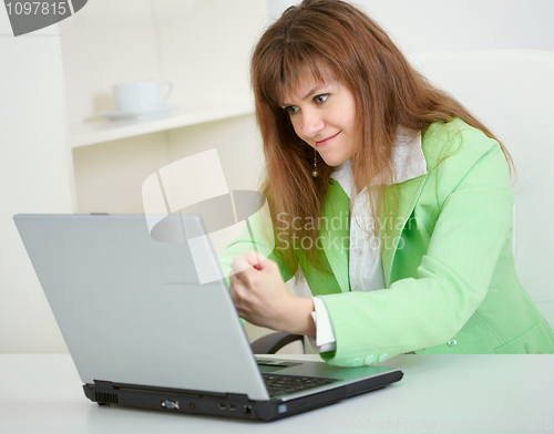 Image of Young woman threatens with fist to virtual interlocutor