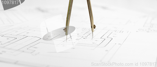 Image of Metal compasses against engineering drawing