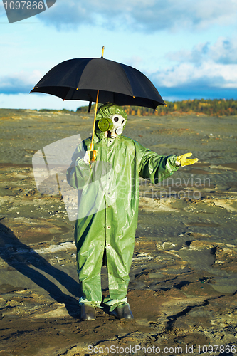 Image of Man in gas mask with umbrella waiting for acid rain