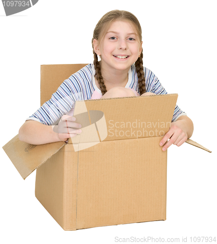 Image of Amusing little girl sits in cardboard box isolated on white back