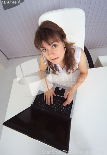Image of Amusing woman sits at table with computer - top view