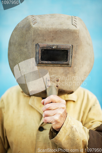 Image of Old welder's helmet in hands of welder