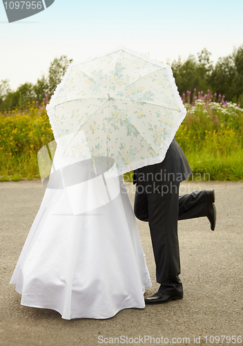 Image of Couple kissing behind an umbrella