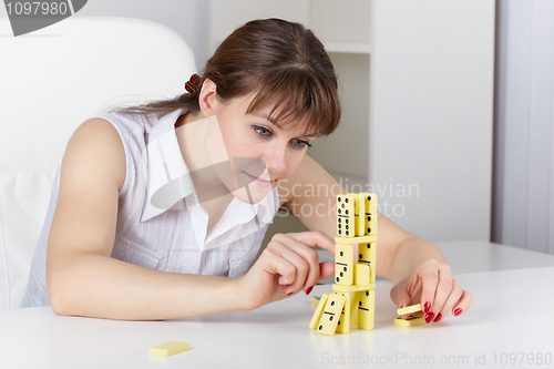 Image of Young woman plays with dominoes