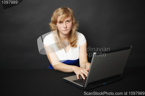 Image of Woman with laptop works in Internet in the evening