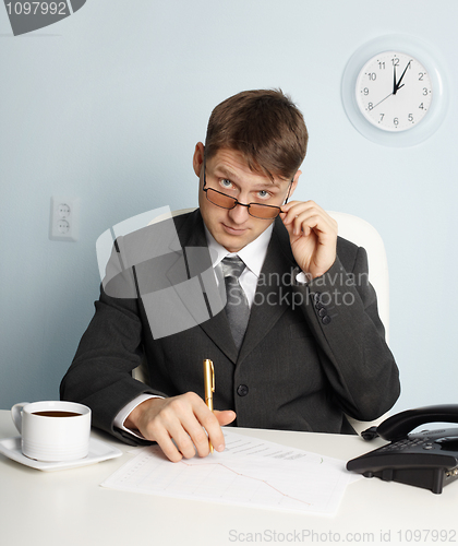 Image of Serious businessman looking above glasses