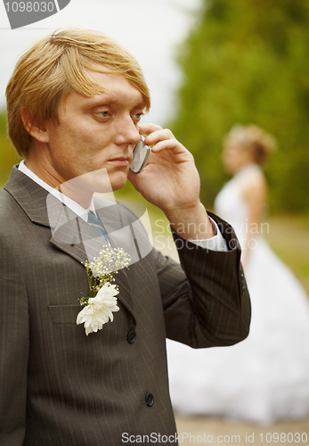 Image of Groom speaks by phone , forgotten about bride