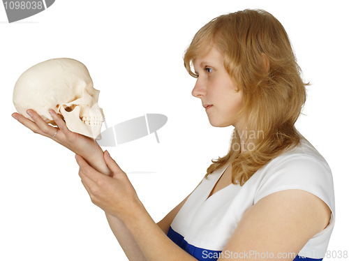 Image of Woman examines a human skull on white