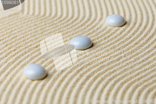 Image of Art composition from white stones on yellow sand