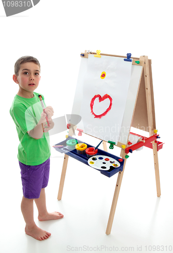 Image of Young child standing at art easel