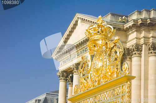 Image of Golden crown over the gate and Palace in Versailles