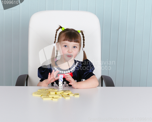 Image of Little amusing girl is playing with toys