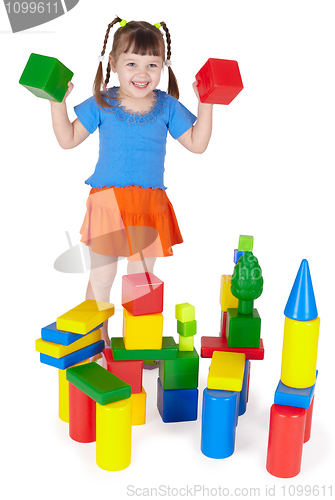 Image of Cheerful girl playing with colored blocks