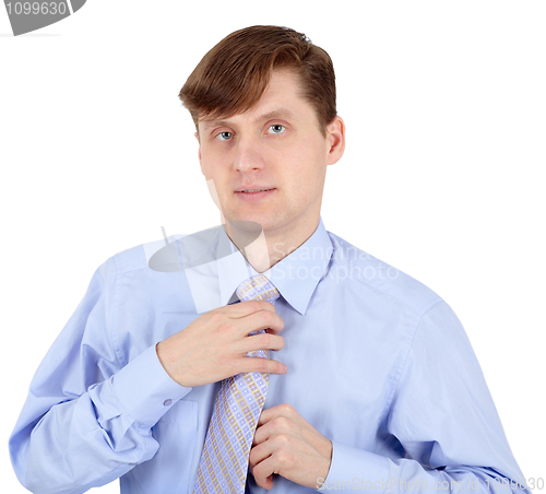 Image of Young man adjusts his tie