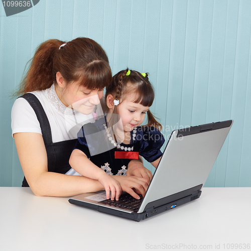 Image of Mom teaches daughter to use computer