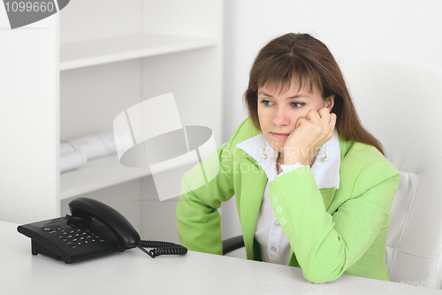 Image of Tired manager reflects at office sitting at table