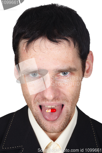 Image of Young man eats a pill put it on tongue
