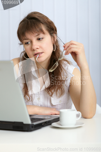 Image of Young woman thought working with computer